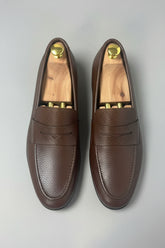 Dark brown leather slip-on loafers with textured finish, perfect for casual or office wear.